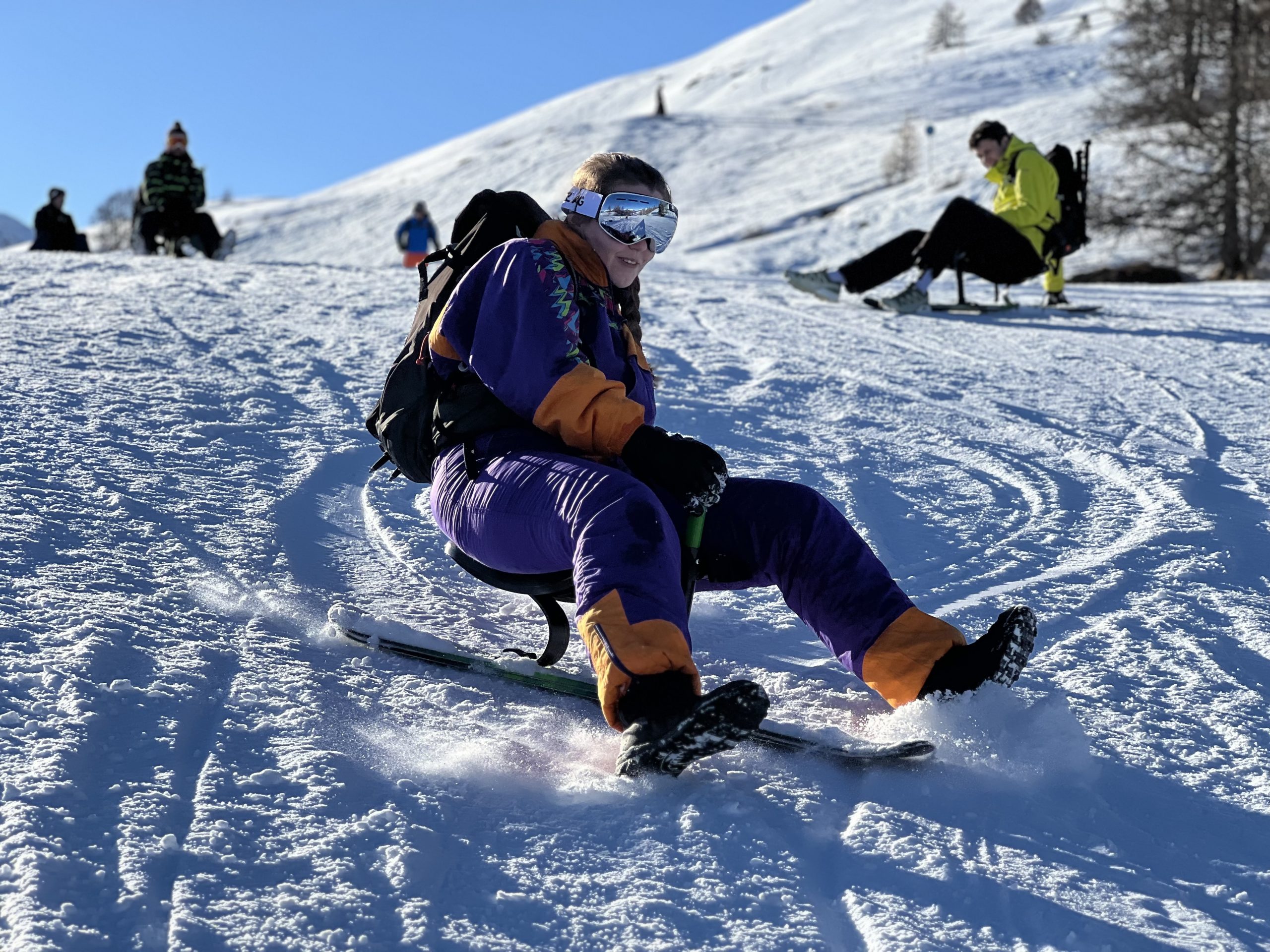 Une participante tout sourire glisse en Snooc sur une piste ensoleillée